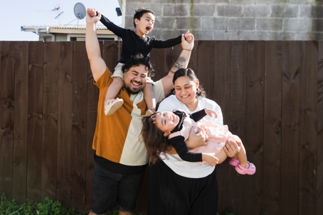 happy parents playing with their young children